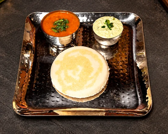 One large thatte idli with coconut chutney and sambar